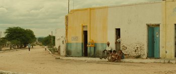 Movie still from “Central Station” (1998), directed by Walter Salles – A group of people sitting on the side of the street; Wide shot, Low angle