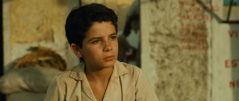 Movie still from “Central Station” (1998), directed by Walter Salles – A young boy sitting in front of a brick wall; Close Up shot, High angle