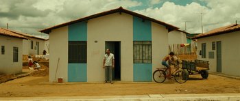 Movie still from “Central Station” (1998), directed by Walter Salles – A man standing in front of a building next to a bicycle; Extreme Wide shot, Low angle