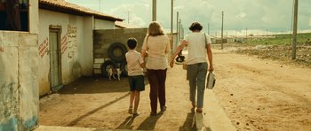 Movie still from “Central Station” (1998), directed by Walter Salles – A woman and two children walking down a dirt road; Wide shot, Over the shoulder angle