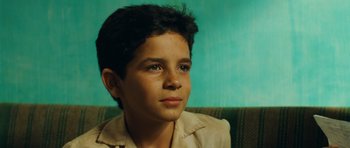 Movie still from “Central Station” (1998), directed by Walter Salles – A young boy sitting on top of a couch; Close Up shot, High angle