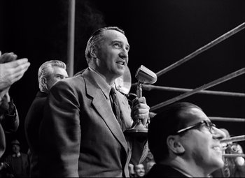 Movie still from “Champion” (1949), directed by Mark Robson – An old photo of a man in a boxing ring; Medium shot, Low angle