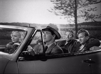 Movie still from “Champion” (1949), directed by Mark Robson – Black and white photograph of men in a car; Wide shot, Over the shoulder angle