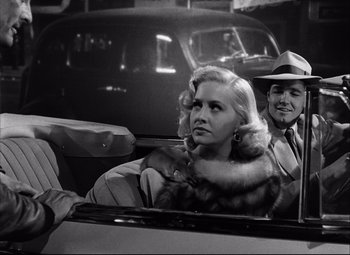Movie still from “Champion” (1949), directed by Mark Robson – A man and a woman sitting in the back of a car; Close Up shot, Over the shoulder angle