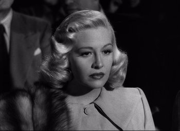 Movie still from “Champion” (1949), directed by Mark Robson – A black and white photo of a woman in a fur coat; Close Up shot, Low angle