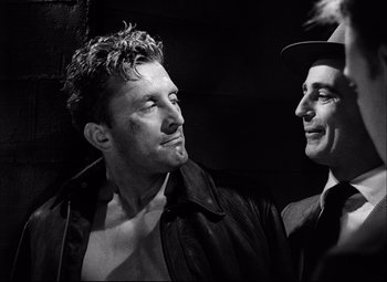 Movie still from “Champion” (1949), directed by Mark Robson – Two men are standing next to each other; Close Up shot, Low angle