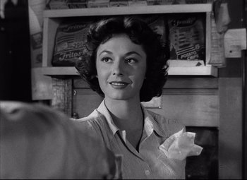 Movie still from “Champion” (1949), directed by Mark Robson – An old black and white photo of a woman in front of a counter; Close Up shot, Low angle