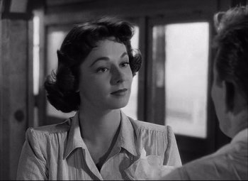 Movie still from “Champion” (1949), directed by Mark Robson – An old photo of an older woman looking at the camera; Close Up shot, Over the shoulder angle