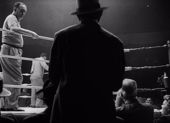 Movie still from “Champion” (1949), directed by Mark Robson – A black and white photo of a boxing match; Medium shot, Low angle