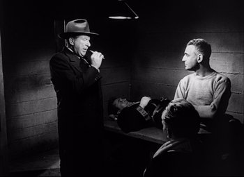 Movie still from “Champion” (1949), directed by Mark Robson – An old black and white photo of a man brushing his teeth; Medium shot, Over the shoulder angle