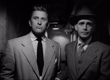 Movie still from “Champion” (1949), directed by Mark Robson – A black and white photo of two men standing next to each other; Medium shot, Low angle