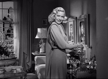 Movie still from “Champion” (1949), directed by Mark Robson – An old photo of a woman standing in a living room; Medium shot, Low angle