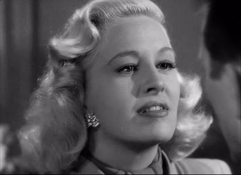 Movie still from “Champion” (1949), directed by Mark Robson – A black - and - white photo of a woman in a dress; Close Up shot, Over the shoulder angle