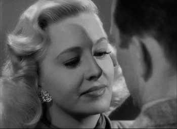 Movie still from “Champion” (1949), directed by Mark Robson – An old photo of a woman and a young man; Close Up shot, Over the shoulder angle