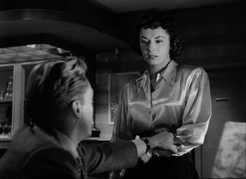 Movie still from “Champion” (1949), directed by Mark Robson – An old photo of a woman and a young man; Medium shot, Over the shoulder angle