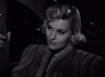 Movie still from “Champion” (1949), directed by Mark Robson – A black and white photo of a woman in a fur coat; Close Up shot, High angle