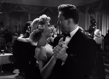 Movie still from “Champion” (1949), directed by Mark Robson – A man and a woman are dancing in a ballroom; Medium shot, Low angle