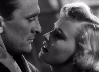 Movie still from “Champion” (1949), directed by Mark Robson – A black and white photo of a man and a woman kissing; Close Up shot, Low angle