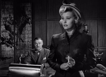 Movie still from “Champion” (1949), directed by Mark Robson – A man and a woman are in a courtroom; Medium shot, Over the shoulder angle
