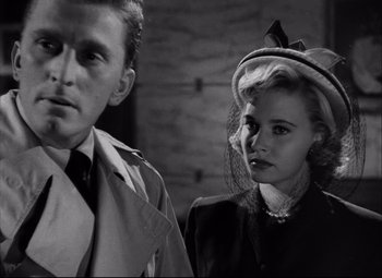 Movie still from “Champion” (1949), directed by Mark Robson – A man and a woman standing next to each other in front of a brick wall; Close Up shot, Over the shoulder angle