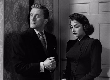 Movie still from “Champion” (1949), directed by Mark Robson – A man and a woman standing next to each other; Medium shot, Low angle