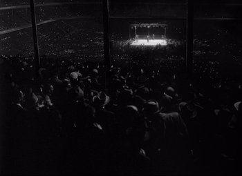 Movie still from “Champion” (1949), directed by Mark Robson – A crowd of people sitting in front of a stage; Extreme Wide shot, High angle