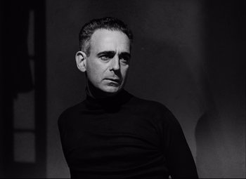 Movie still from “Champion” (1949), directed by Mark Robson – A black and white photo of a man wearing a black shirt; Close Up shot, Low angle