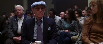Movie still from “Changing Lanes” (2002), directed by Roger Michell – An old man wearing a blue hat and a tie; Medium shot, Low angle