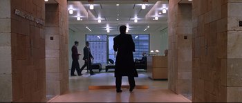 Movie still from “Changing Lanes” (2002), directed by Roger Michell – A group of people walking in a room; Wide shot, Low angle