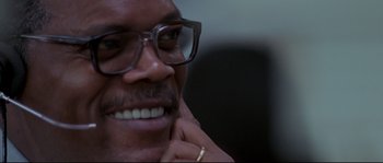 Movie still from “Changing Lanes” (2002), directed by Roger Michell – A person wearing glasses and smiling; Close Up shot, Low angle