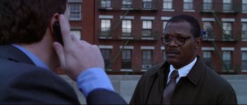 Movie still from “Changing Lanes” (2002), directed by Roger Michell – A man shaking hands with another man in front of a brick building; Close Up shot, Over the shoulder angle