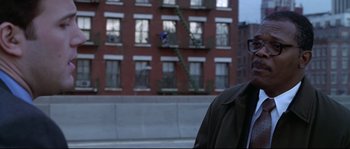 Movie still from “Changing Lanes” (2002), directed by Roger Michell – A man standing in front of a brick building; Medium shot, Low angle