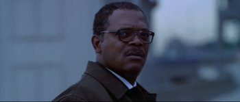 Movie still from “Changing Lanes” (2002), directed by Roger Michell – A person wearing glasses and a jacket; Close Up shot, Low angle