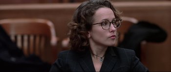 Movie still from “Changing Lanes” (2002), directed by Roger Michell – A woman in a black suit and glasses looks to her left; Close Up shot, Over the shoulder angle
