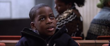 Movie still from “Changing Lanes” (2002), directed by Roger Michell – A young boy sitting in front of a woman in a black jacket; Close Up shot, Over the shoulder angle