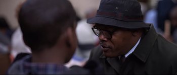 Movie still from “Changing Lanes” (2002), directed by Roger Michell – A man wearing a hat talking to another man; Close Up shot, Over the shoulder angle