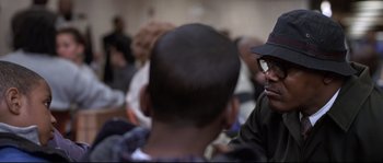 Movie still from “Changing Lanes” (2002), directed by Roger Michell – A group of people sitting in a room talking to each other; Close Up shot, Over the shoulder angle