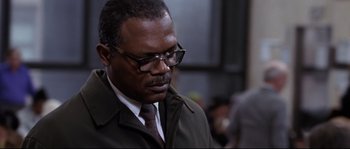 Movie still from “Changing Lanes” (2002), directed by Roger Michell – A man in a suit and tie looking down; Close Up shot, Low angle