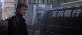 Movie still from “Changing Lanes” (2002), directed by Roger Michell – A man standing in the rain next to a truck; Medium shot, Low angle
