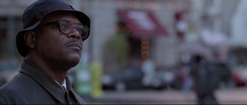 Movie still from “Changing Lanes” (2002), directed by Roger Michell – An older man wearing glasses and a hat is standing on the street; Close Up shot, Low angle