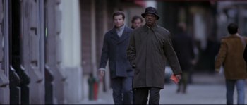 Movie still from “Changing Lanes” (2002), directed by Roger Michell – Two men walking down the street wearing coats and hats; Medium shot, Low angle