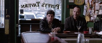 Movie still from “Changing Lanes” (2002), directed by Roger Michell – A man sitting at a table in front of a window; Medium shot, Low angle