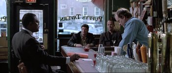 Movie still from “Changing Lanes” (2002), directed by Roger Michell – A group of people sitting at a bar; Medium shot, Over the shoulder angle