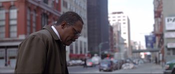 Movie still from “Changing Lanes” (2002), directed by Roger Michell – A person walking on the street; Medium shot, Low angle