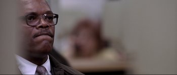 Movie still from “Changing Lanes” (2002), directed by Roger Michell – A man wearing glasses sitting in front of a table; Close Up shot, Low angle