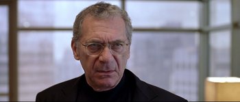 Movie still from “Changing Lanes” (2002), directed by Roger Michell – An older man wearing glasses and wearing a black shirt; Close Up shot, Low angle