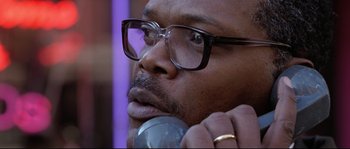 Movie still from “Changing Lanes” (2002), directed by Roger Michell – A person wearing glasses and holding a phone; Close Up shot, Low angle