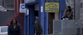 Movie still from “Changing Lanes” (2002), directed by Roger Michell – A man standing in front of an official inspection station; Medium shot, Low angle