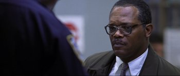 Movie still from “Changing Lanes” (2002), directed by Roger Michell – An older man wearing a suit and glasses; Close Up shot, Over the shoulder angle