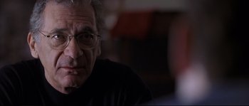 Movie still from “Changing Lanes” (2002), directed by Roger Michell – An older man wearing glasses looking at the camera; Close Up shot, Over the shoulder angle
